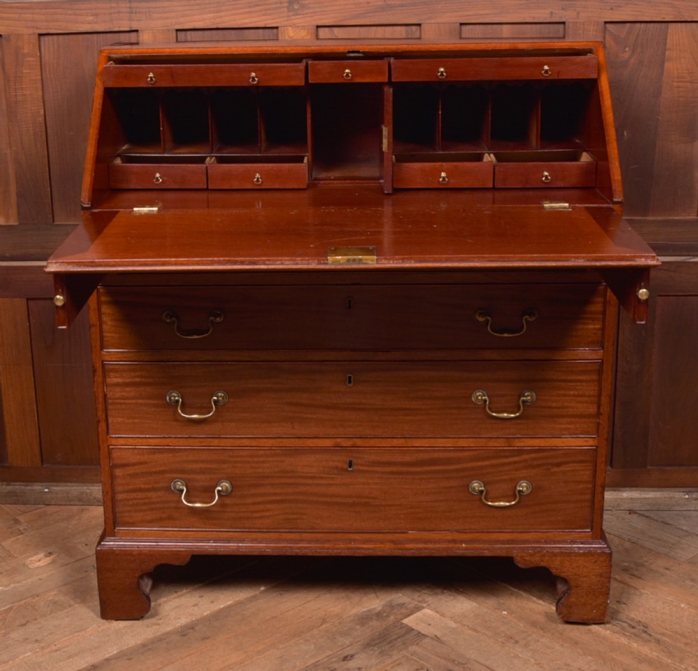 A Georgian mahogany writing bureau featuring a sloped fall-front writing flap above four graduated drawers with brass swan-neck handles and bracket feet. View VIII