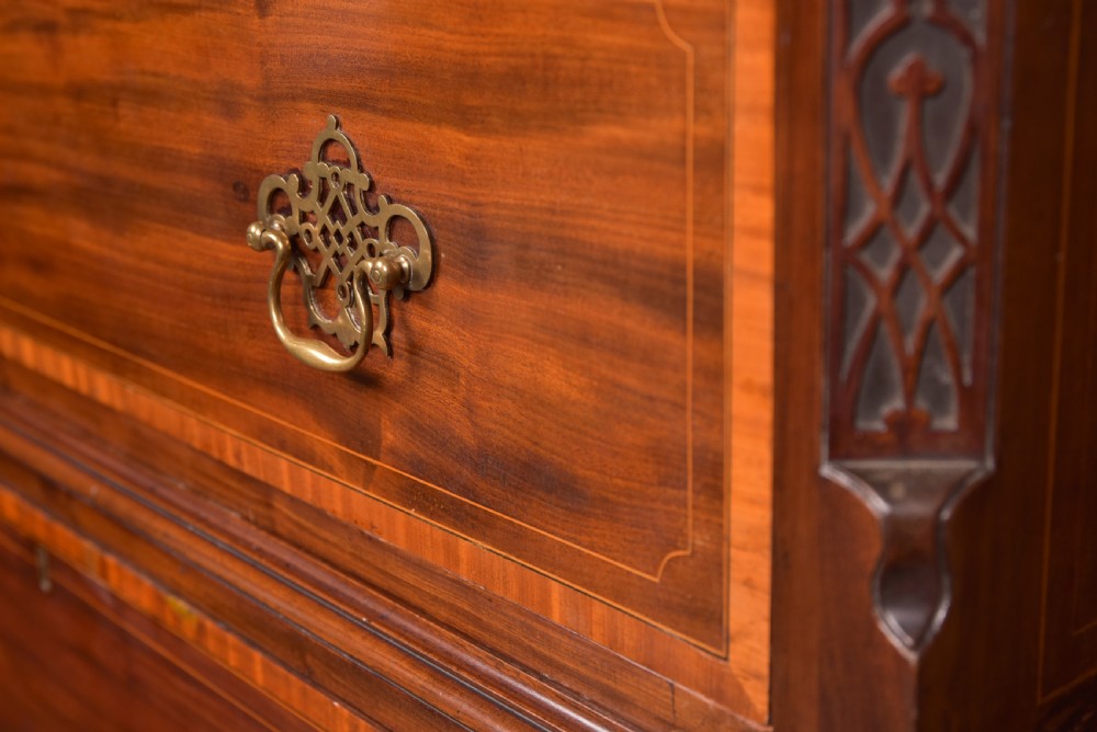 A tall Georgian mahogany chest on chest featuring inlaid drawer borders, brass handles, dentil cornice detail, and bracket feet. View II