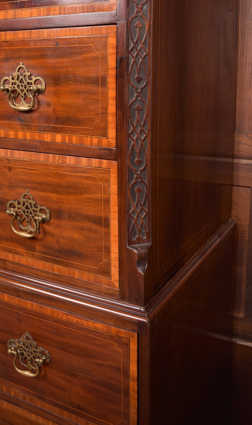 A tall Georgian mahogany chest on chest featuring inlaid drawer borders, brass handles, dentil cornice detail, and bracket feet. View VII