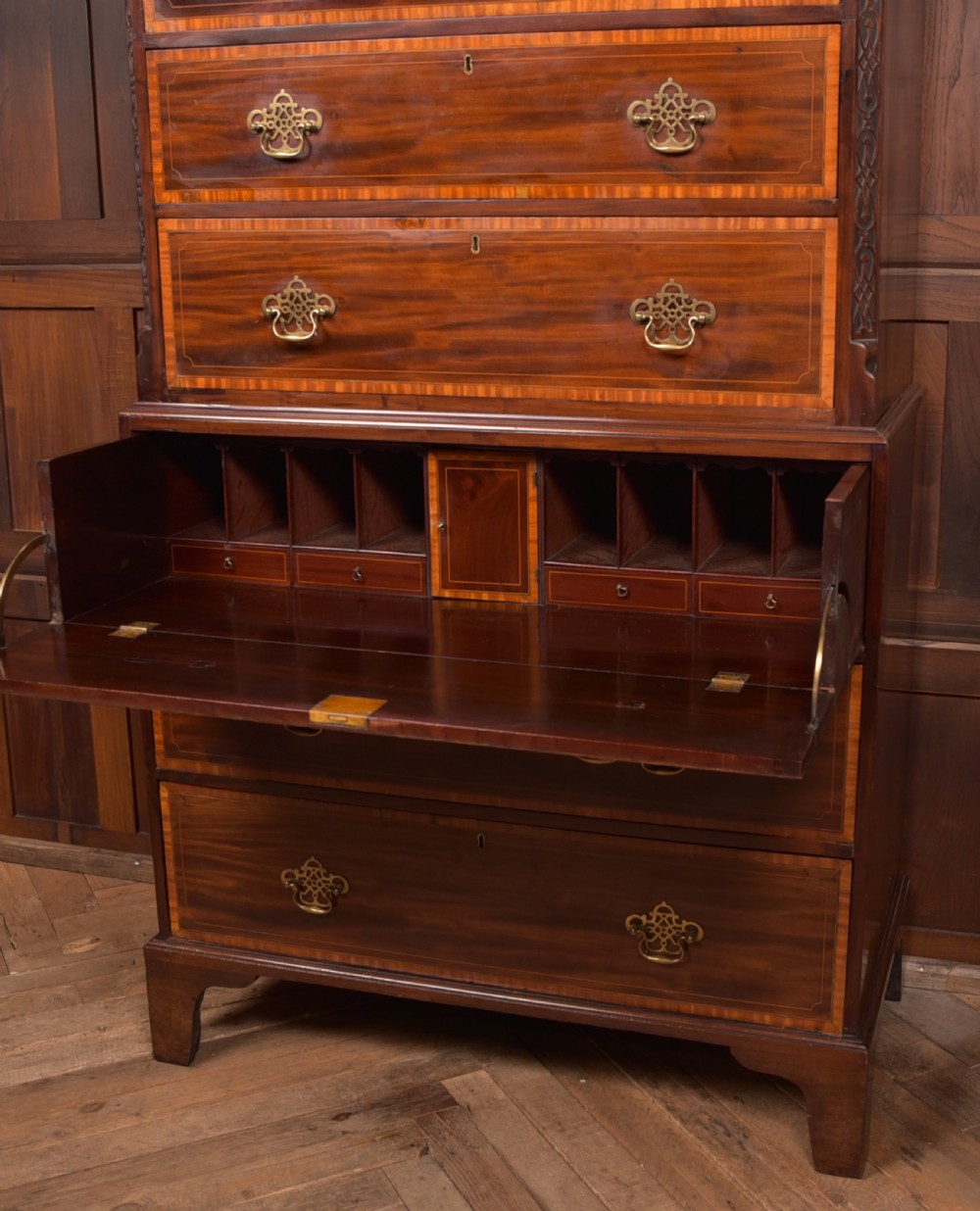 A tall Georgian mahogany chest on chest featuring inlaid drawer borders, brass handles, dentil cornice detail, and bracket feet. View VIII