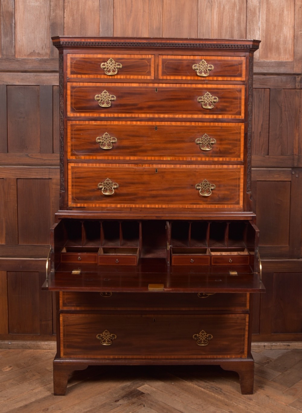 A tall Georgian mahogany chest on chest featuring inlaid drawer borders, brass handles, dentil cornice detail, and bracket feet. View XI
