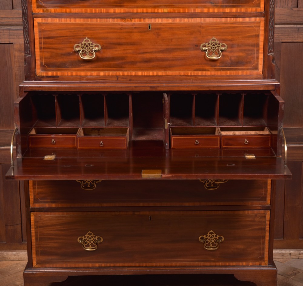 A tall Georgian mahogany chest on chest featuring inlaid drawer borders, brass handles, dentil cornice detail, and bracket feet. View XII