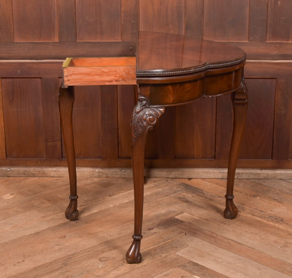An Edwardian mahogany demi-lune card table featuring carved cabriole legs and a polished fold-over top. View VII