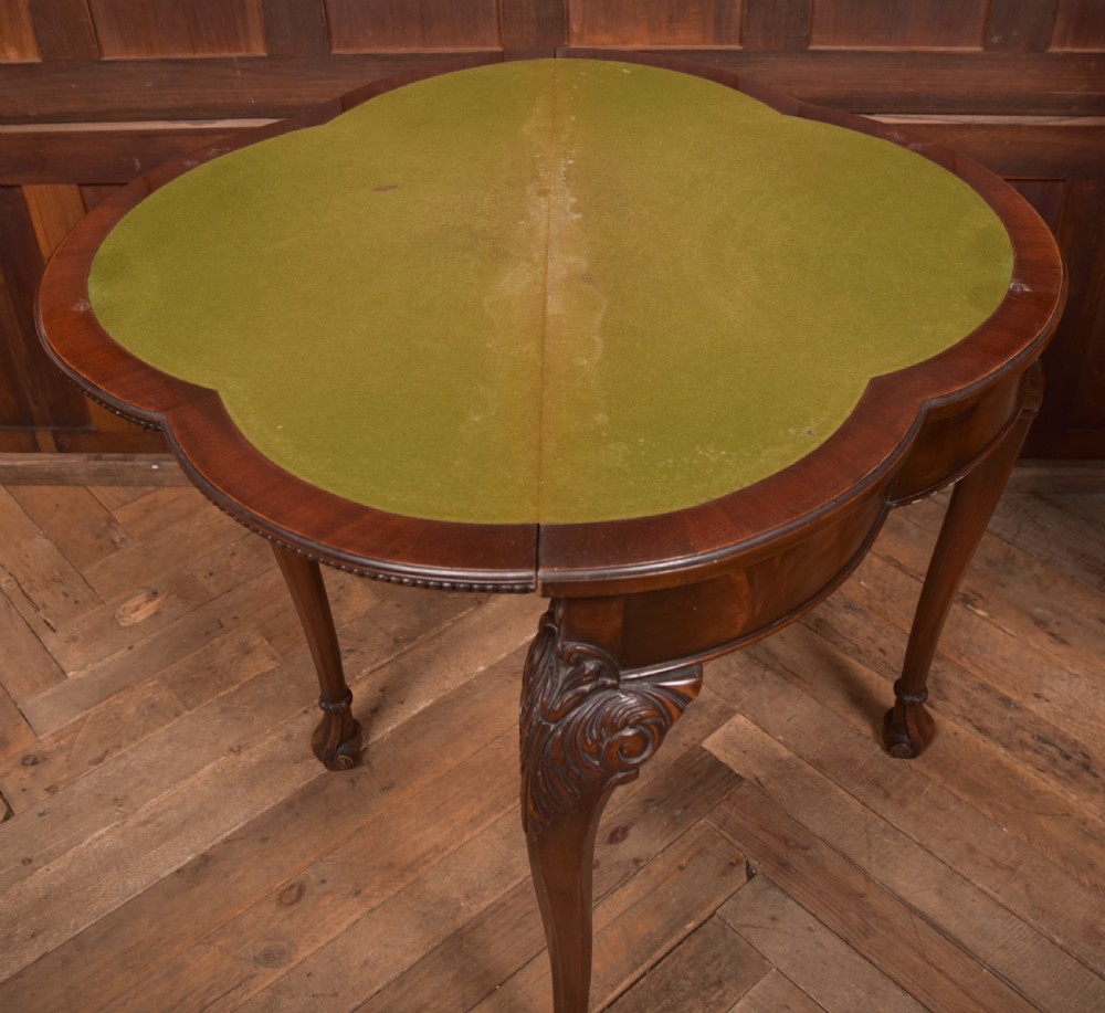 An Edwardian mahogany demi-lune card table featuring carved cabriole legs and a polished fold-over top. View X
