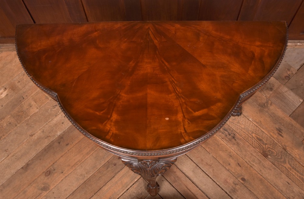 An Edwardian mahogany demi-lune card table featuring carved cabriole legs and a polished fold-over top. View XIV