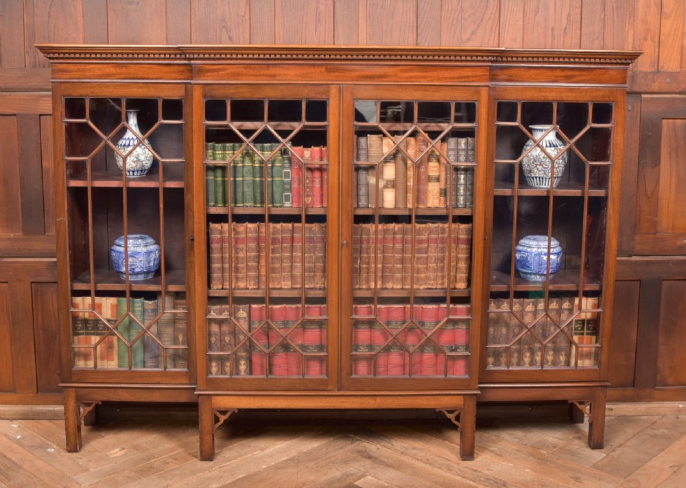 A large mahogany Chinese Chippendale style breakout bookcase featuring four glazed doors with lattice astragal glazing and dentil moulding along the top.