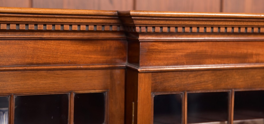 A large mahogany Chinese Chippendale style breakout bookcase featuring four glazed doors with lattice astragal glazing and dentil moulding along the top. View III
