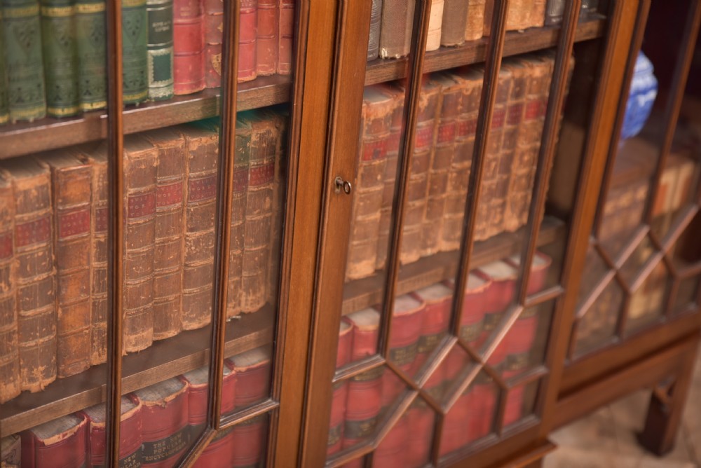 A large mahogany Chinese Chippendale style breakout bookcase featuring four glazed doors with lattice astragal glazing and dentil moulding along the top. View V