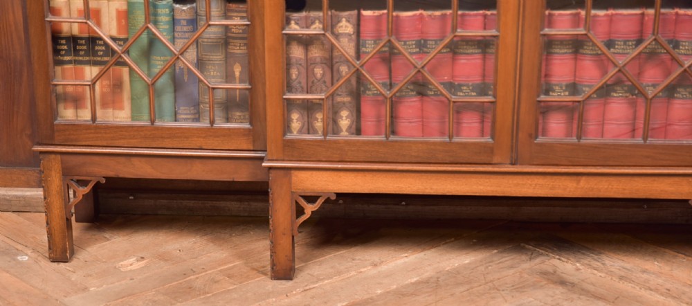 A large mahogany Chinese Chippendale style breakout bookcase featuring four glazed doors with lattice astragal glazing and dentil moulding along the top. View VIII