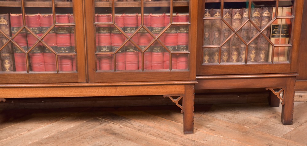 A large mahogany Chinese Chippendale style breakout bookcase featuring four glazed doors with lattice astragal glazing and dentil moulding along the top. View XIII