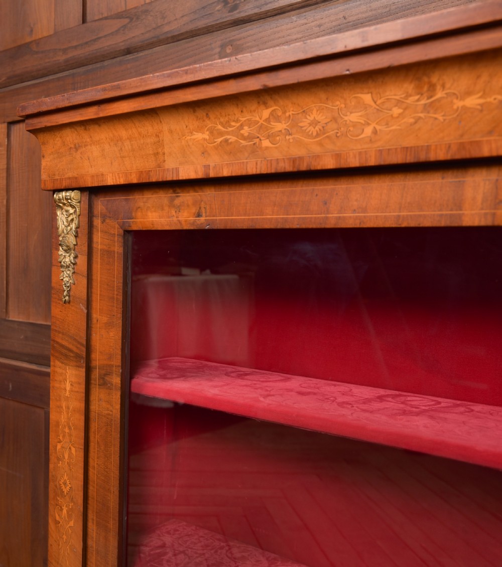 A Victorian walnut pier cabinet with a glazed single door, floral marquetry inlay, gilded ormolu mounts, and a red fabric-lined interior with shelves. View XIII