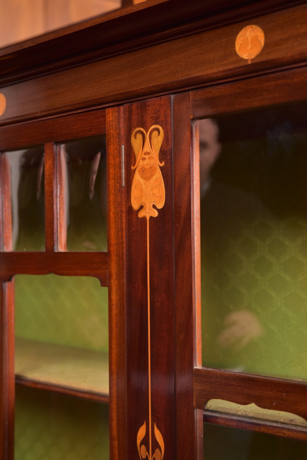 An Art Nouveau mahogany display cabinet featuring stylised floral marquetry inlays, glazed doors, an open upper gallery, and a lower shelf. View XIII
