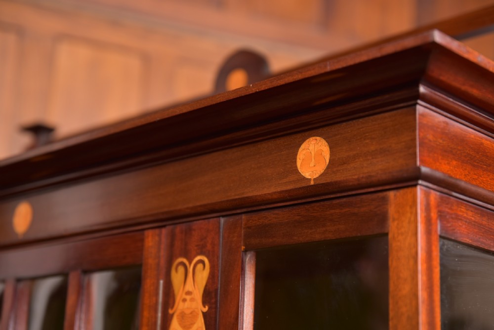 An Art Nouveau mahogany display cabinet featuring stylised floral marquetry inlays, glazed doors, an open upper gallery, and a lower shelf. View XIV