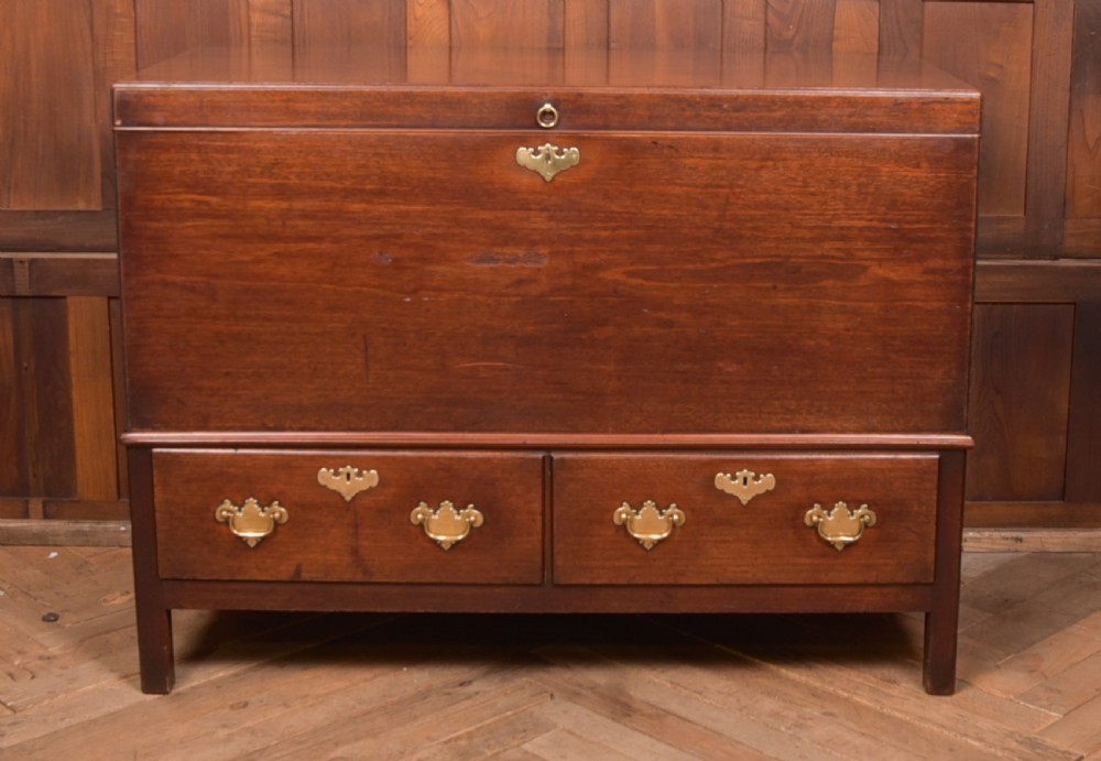 A Georgian mahogany mule chest featuring a hinged top lid above two lower drawers fitted with brass handles and keyhole escutcheons.