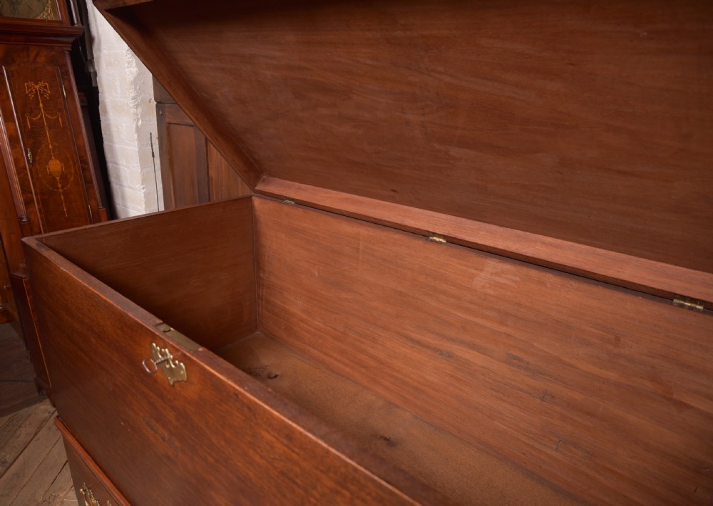 A Georgian mahogany mule chest featuring a hinged top lid above two lower drawers fitted with brass handles and keyhole escutcheons. View IX