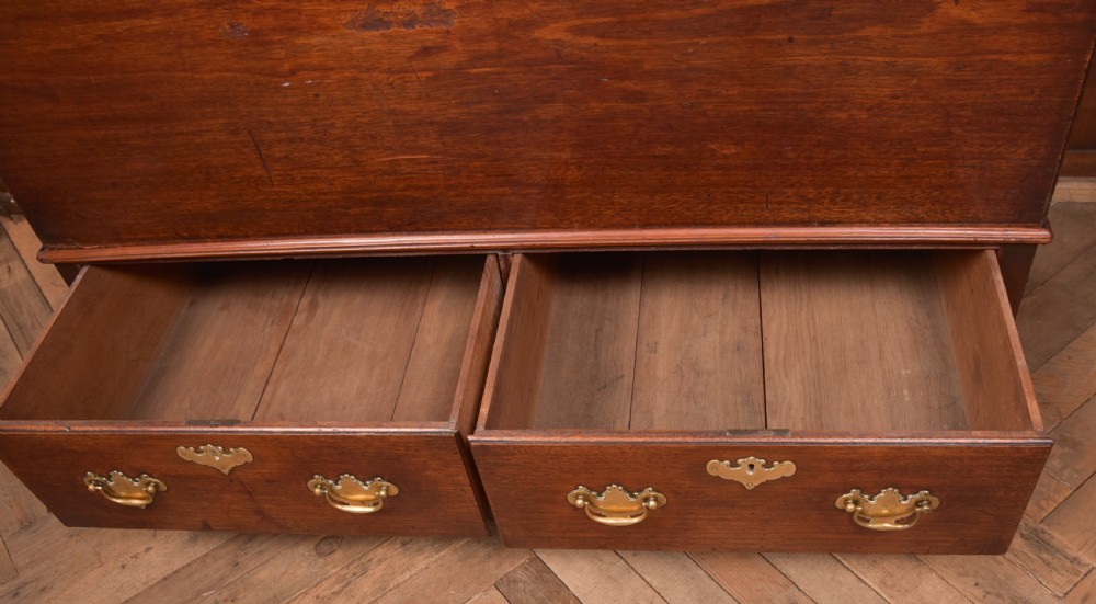 A Georgian mahogany mule chest featuring a hinged top lid above two lower drawers fitted with brass handles and keyhole escutcheons. View XIV