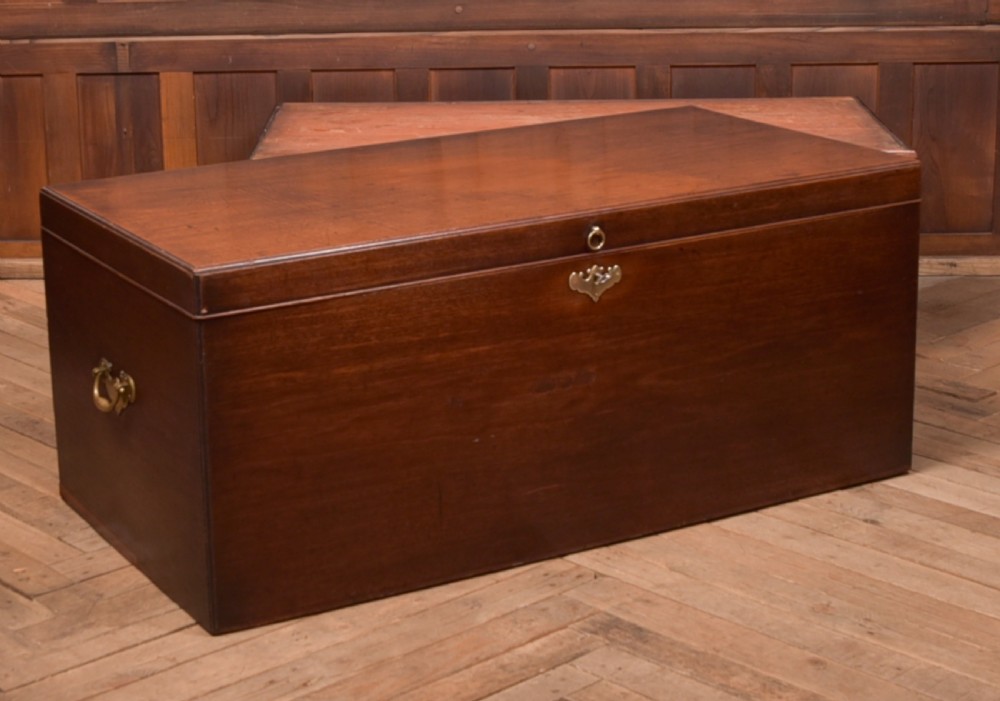 A Georgian mahogany mule chest featuring a hinged top lid above two lower drawers fitted with brass handles and keyhole escutcheons. View XVIII