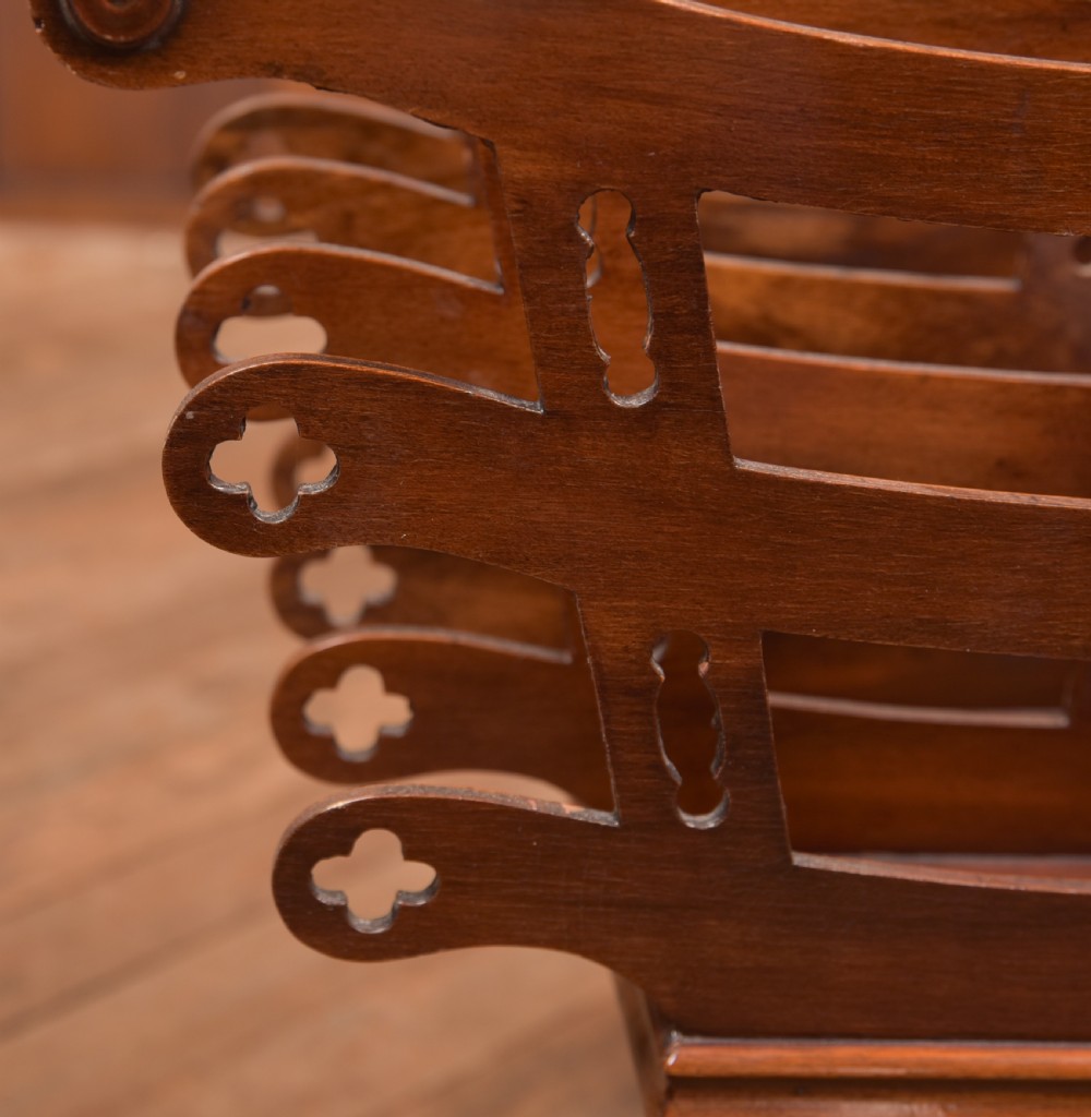 Victorian mahogany sheet music rack featuring pierced fretwork sides, divided compartments, a turned pedestal column, and carved scroll feet. View V