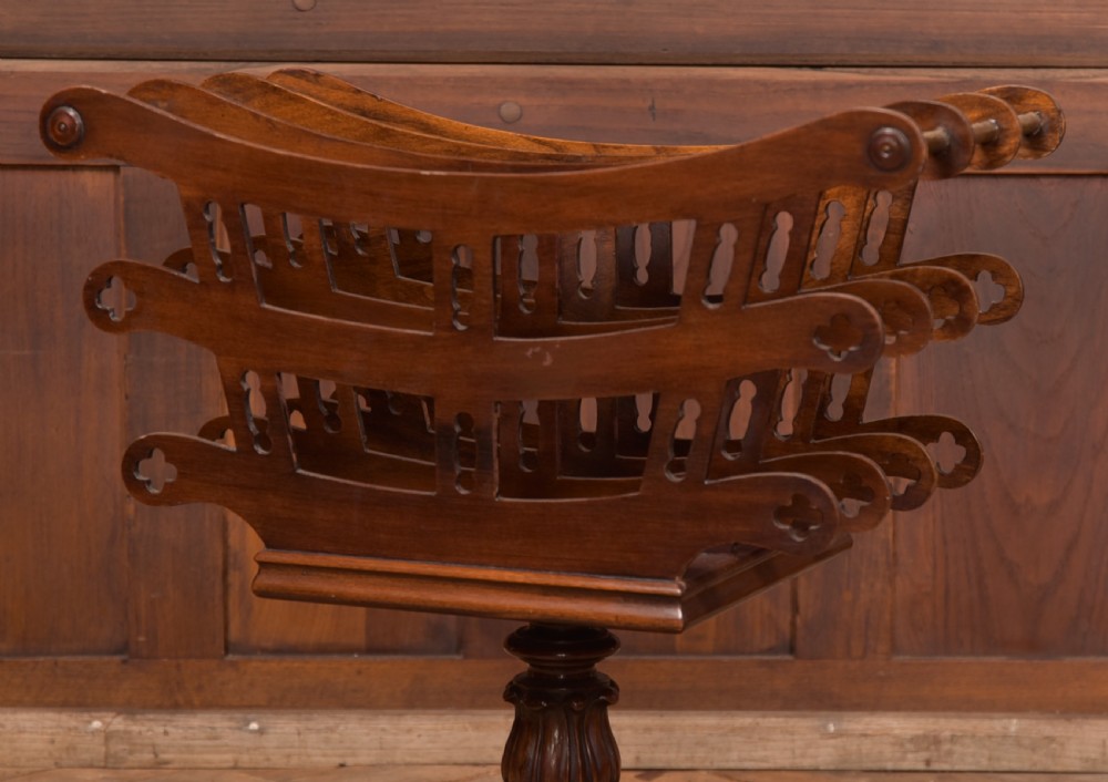 Victorian mahogany sheet music rack featuring pierced fretwork sides, divided compartments, a turned pedestal column, and carved scroll feet. View VI