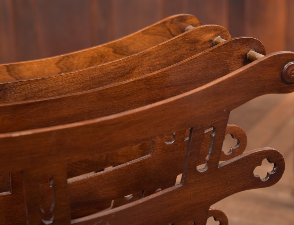 Victorian mahogany sheet music rack featuring pierced fretwork sides, divided compartments, a turned pedestal column, and carved scroll feet. View X