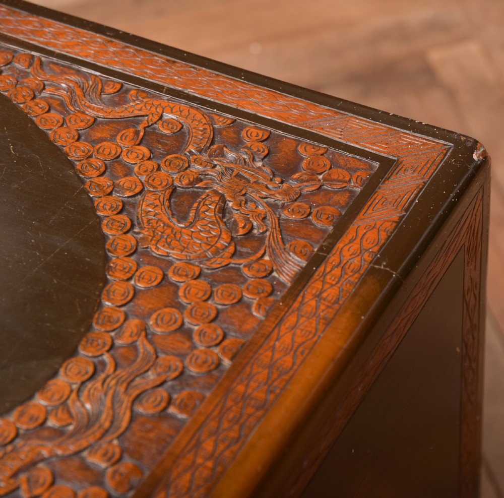 A hand-carved Chinese camphor wood storage chest featuring an oval relief medallion, dragon carvings, and a brass latch plate. View XVII