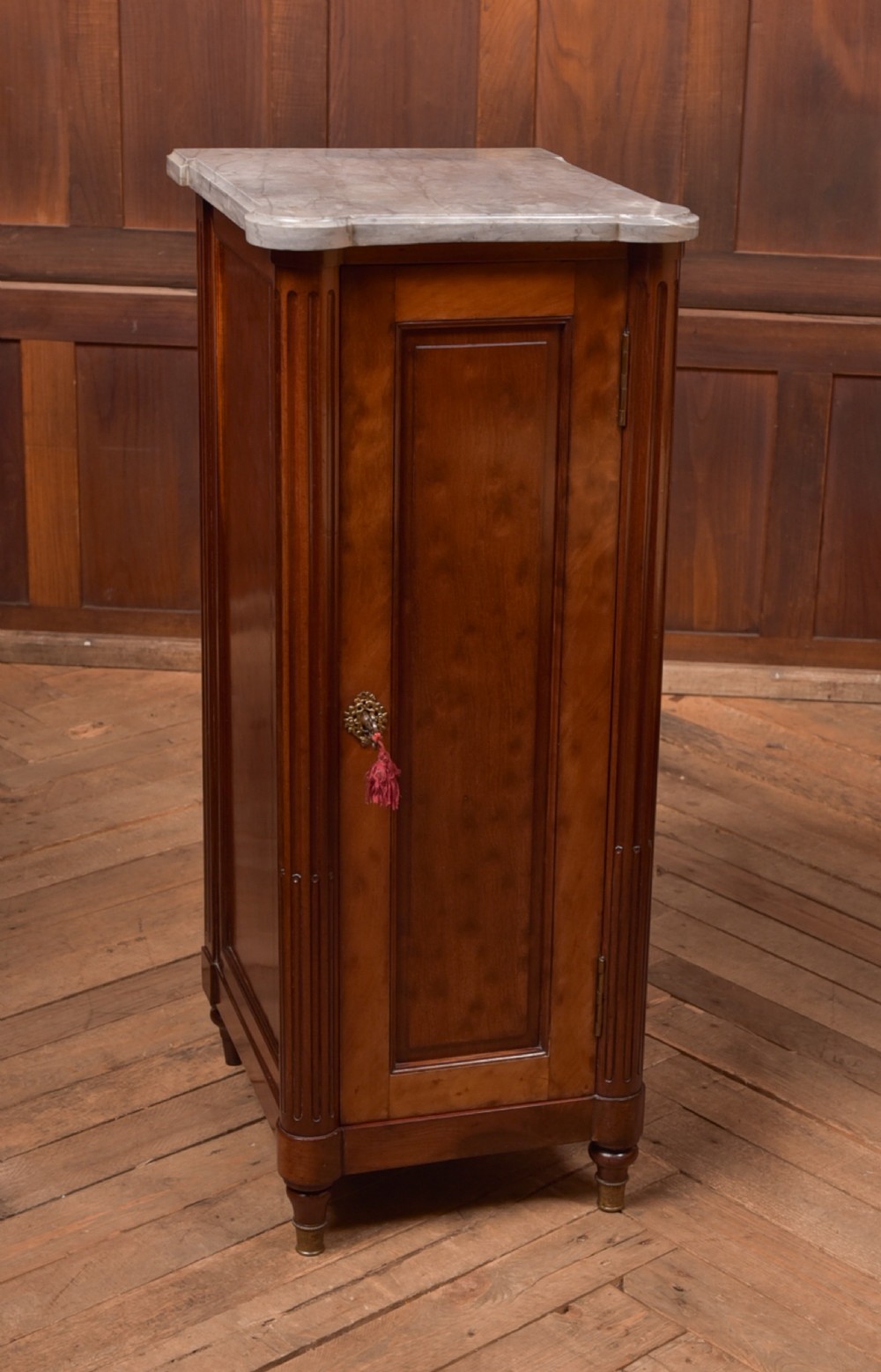 A tall Victorian mahogany cabinet featuring a single panelled door, fluted corner columns, a brass escutcheon, and a white marble top. View III