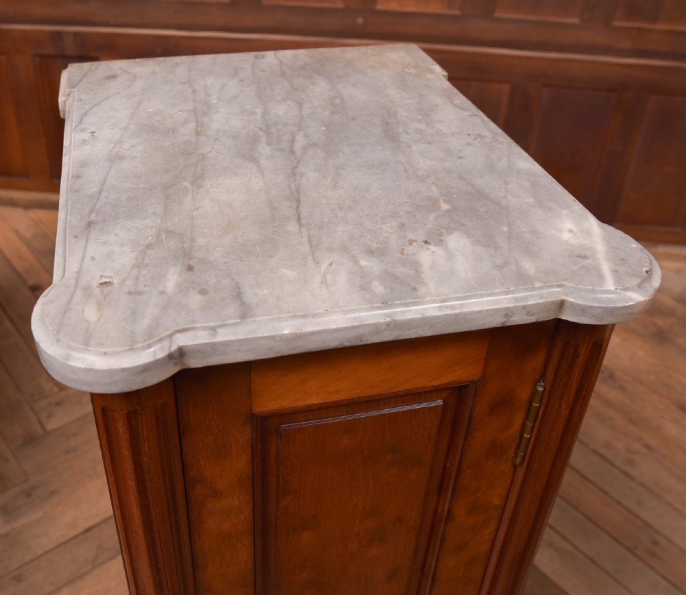A tall Victorian mahogany cabinet featuring a single panelled door, fluted corner columns, a brass escutcheon, and a white marble top. View V