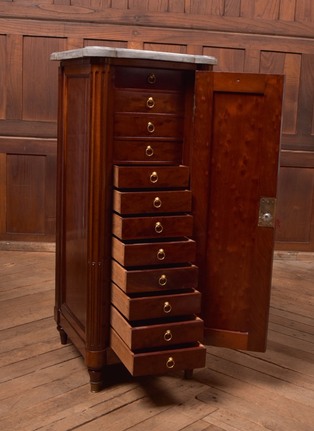 A tall Victorian mahogany cabinet featuring a single panelled door, fluted corner columns, a brass escutcheon, and a white marble top. View VII