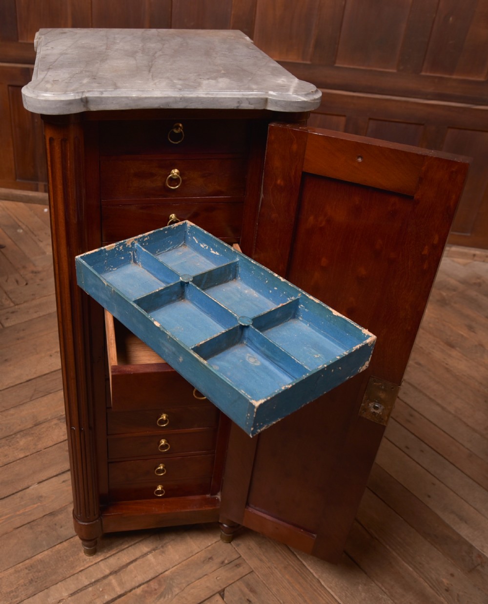 A tall Victorian mahogany cabinet featuring a single panelled door, fluted corner columns, a brass escutcheon, and a white marble top. View X