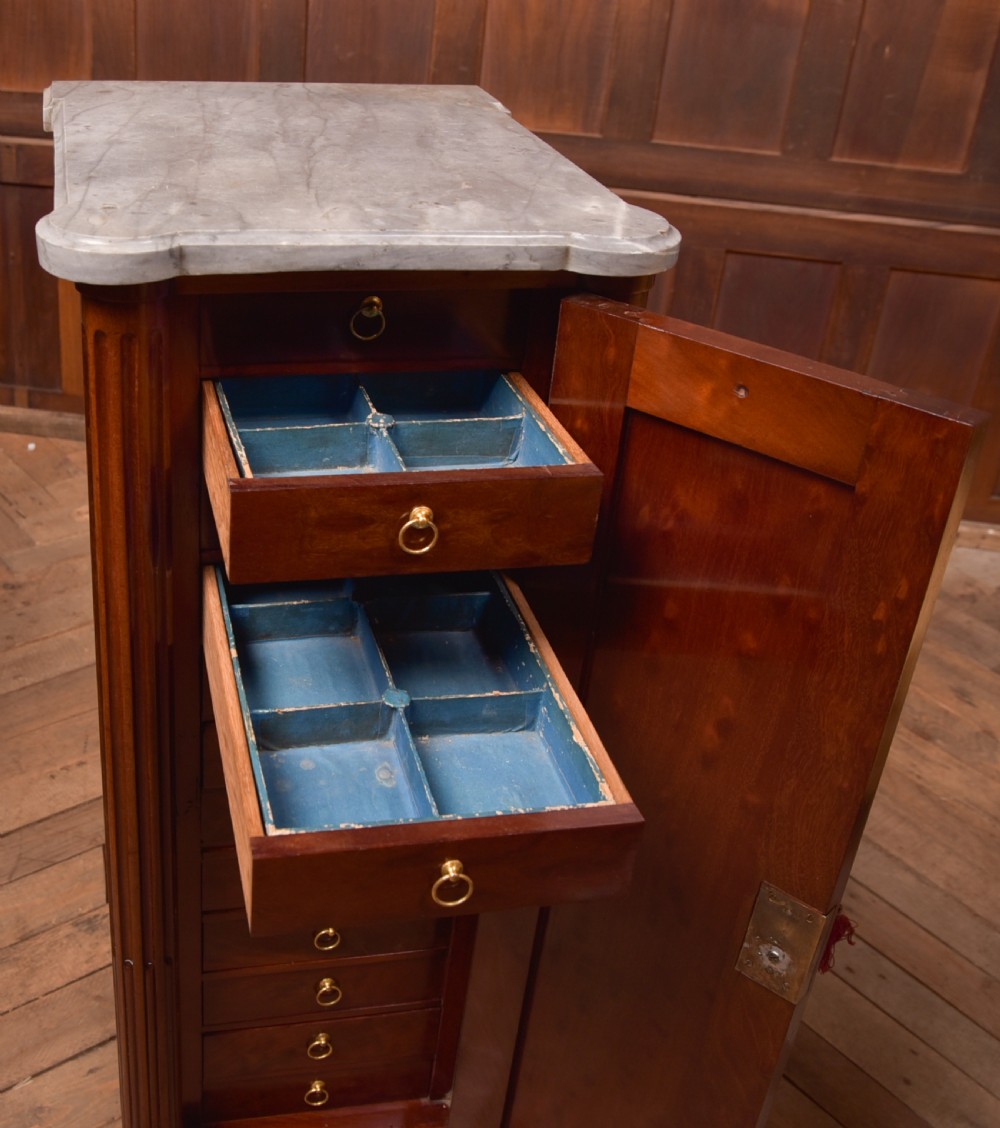 A tall Victorian mahogany cabinet featuring a single panelled door, fluted corner columns, a brass escutcheon, and a white marble top. View XI