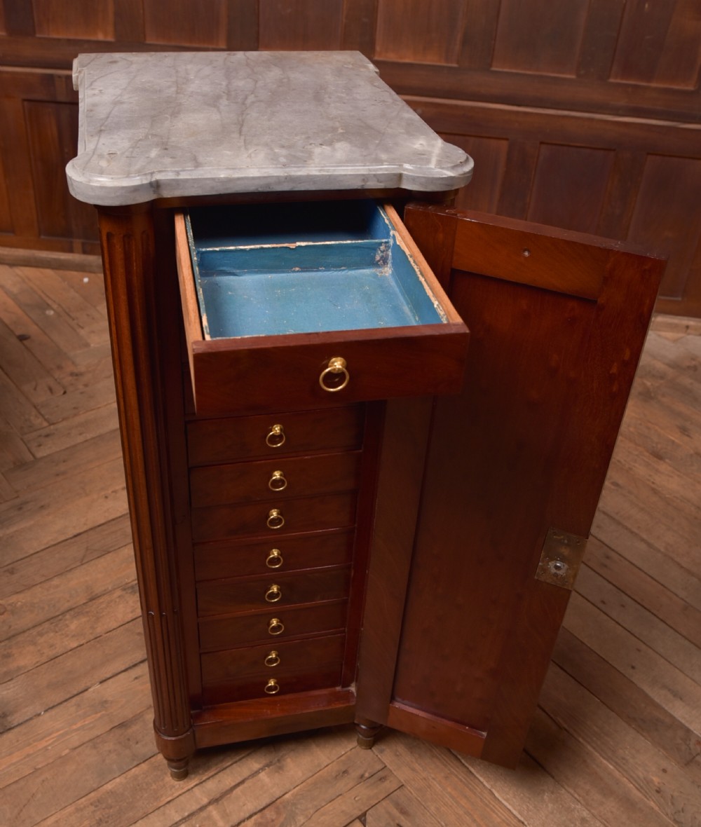 A tall Victorian mahogany cabinet featuring a single panelled door, fluted corner columns, a brass escutcheon, and a white marble top. View XII