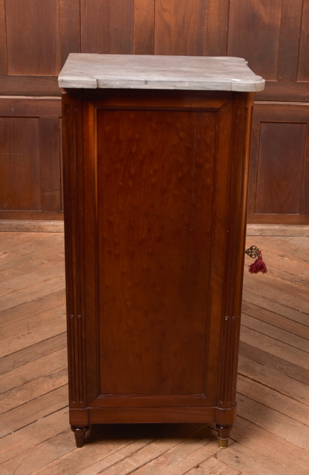 A tall Victorian mahogany cabinet featuring a single panelled door, fluted corner columns, a brass escutcheon, and a white marble top. View XIII