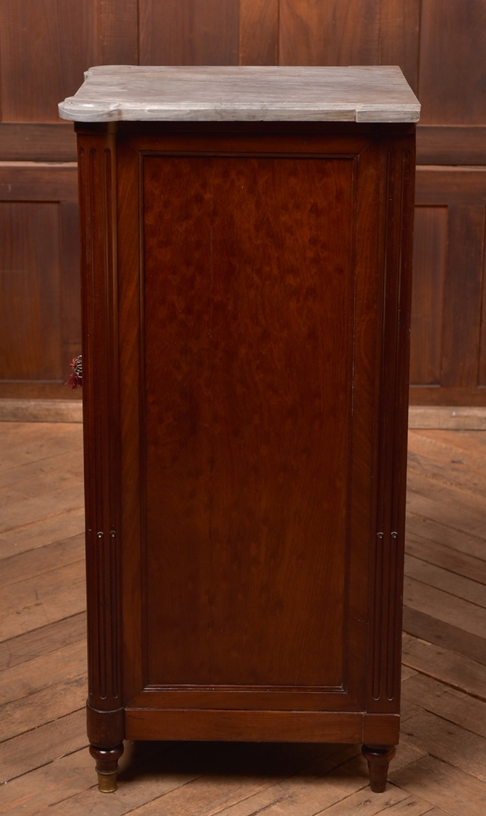 A tall Victorian mahogany cabinet featuring a single panelled door, fluted corner columns, a brass escutcheon, and a white marble top. View XIV