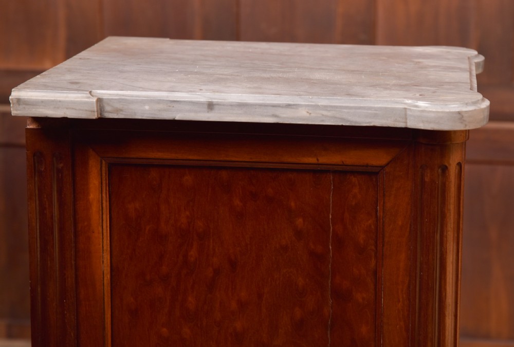 A tall Victorian mahogany cabinet featuring a single panelled door, fluted corner columns, a brass escutcheon, and a white marble top. View XVI