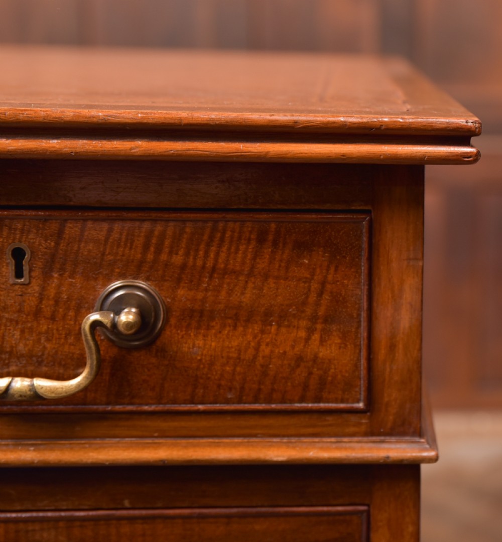 An Edwardian mahogany kneehole writing desk featuring a leather inset top, nine drawers with brass swan neck handles, and carved cabriole legs on ball and claw feet. View III