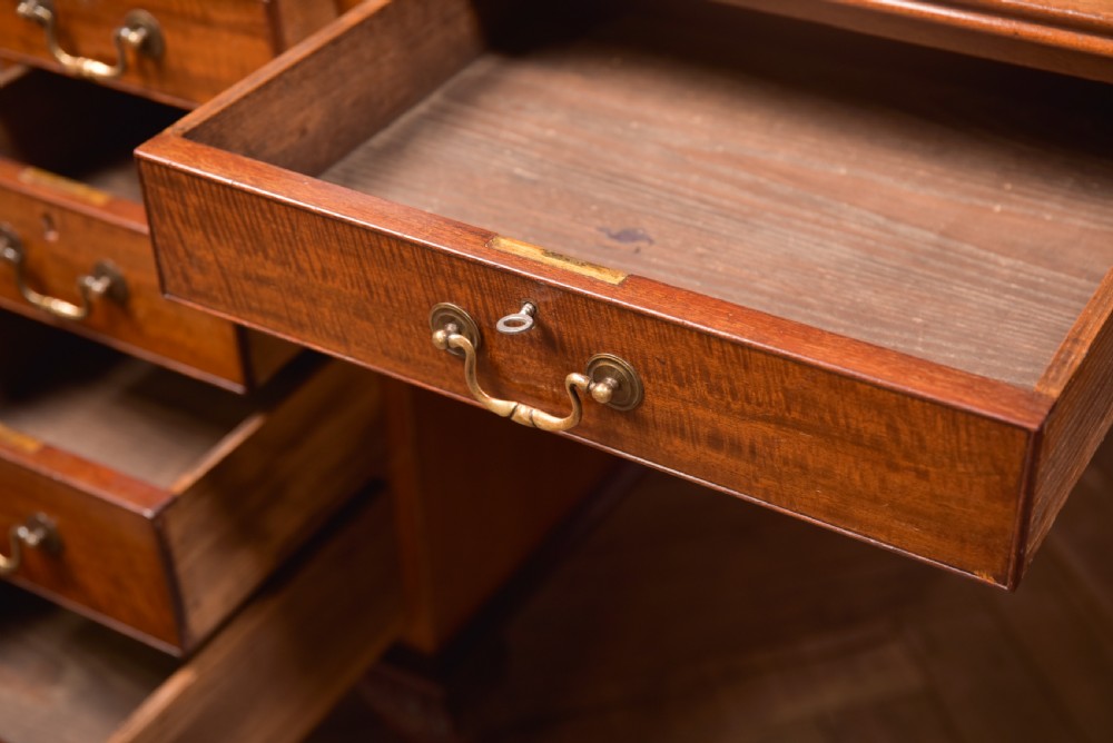 An Edwardian mahogany kneehole writing desk featuring a leather inset top, nine drawers with brass swan neck handles, and carved cabriole legs on ball and claw feet. View XIII