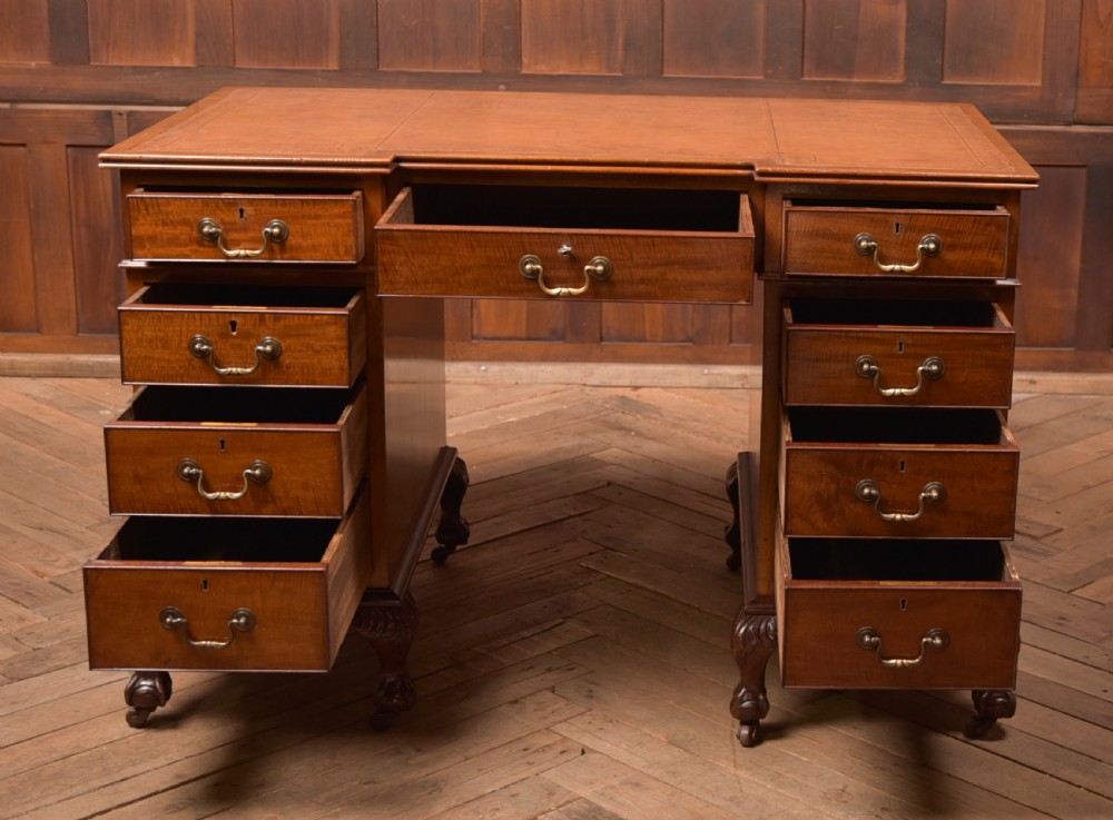 An Edwardian mahogany kneehole writing desk featuring a leather inset top, nine drawers with brass swan neck handles, and carved cabriole legs on ball and claw feet. View XIV