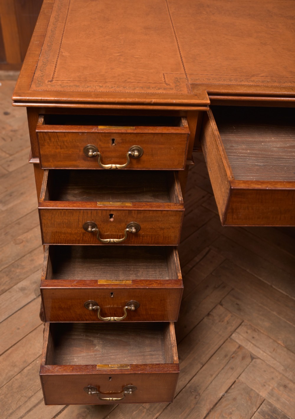 An Edwardian mahogany kneehole writing desk featuring a leather inset top, nine drawers with brass swan neck handles, and carved cabriole legs on ball and claw feet. View XV