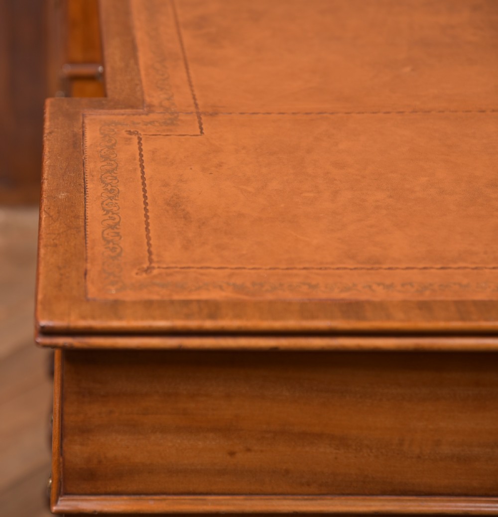 An Edwardian mahogany kneehole writing desk featuring a leather inset top, nine drawers with brass swan neck handles, and carved cabriole legs on ball and claw feet. View XVII
