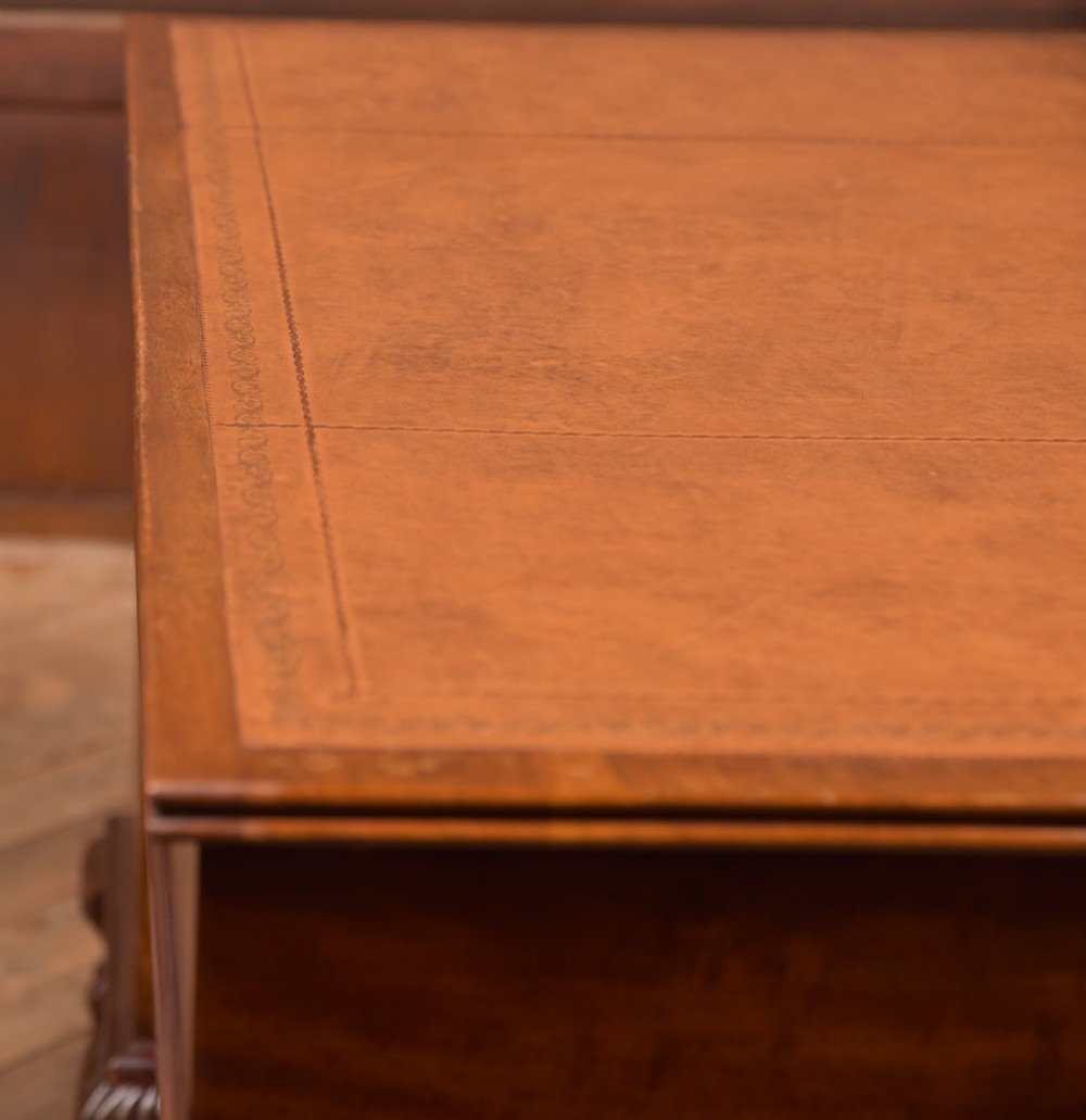 An Edwardian mahogany kneehole writing desk featuring a leather inset top, nine drawers with brass swan neck handles, and carved cabriole legs on ball and claw feet. View XXI