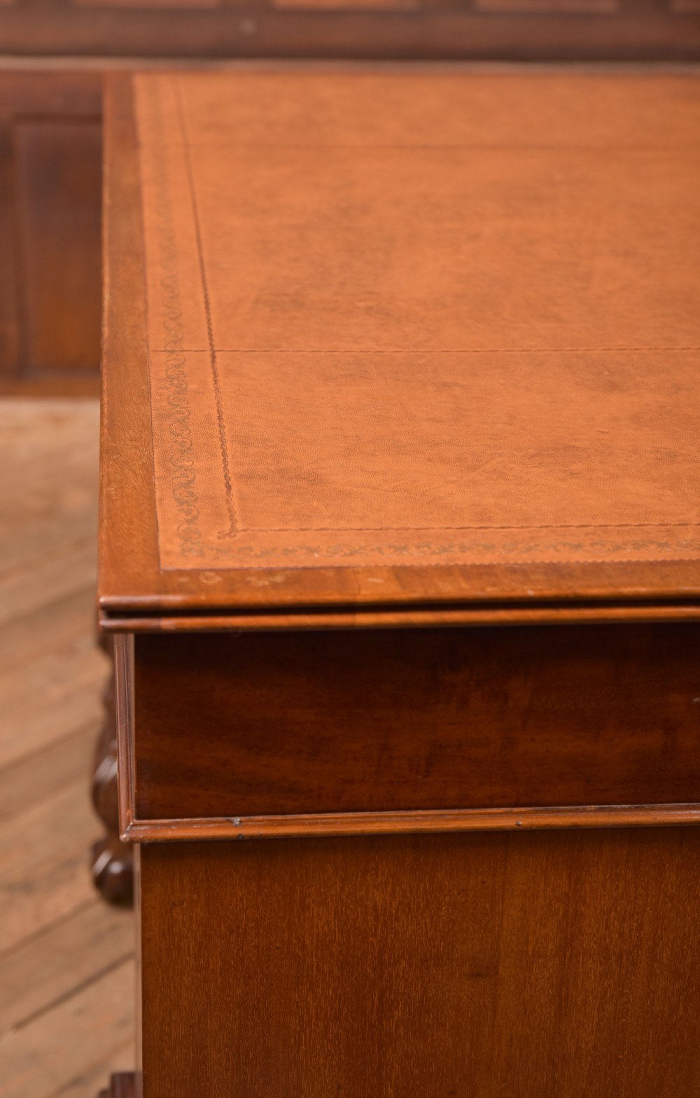An Edwardian mahogany kneehole writing desk featuring a leather inset top, nine drawers with brass swan neck handles, and carved cabriole legs on ball and claw feet. View XXII