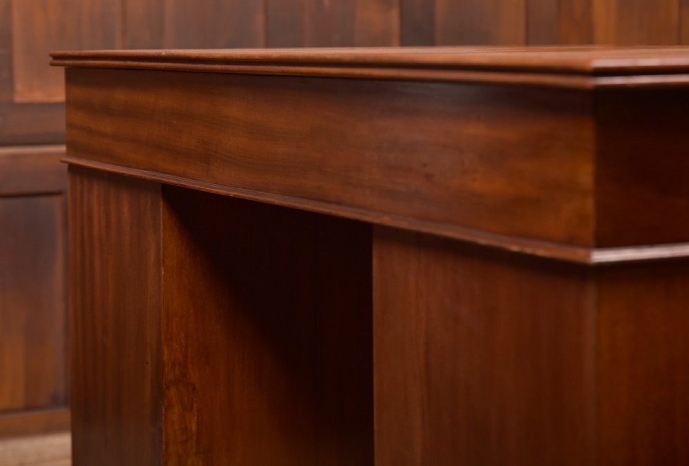 An Edwardian mahogany kneehole writing desk featuring a leather inset top, nine drawers with brass swan neck handles, and carved cabriole legs on ball and claw feet. View XXIV