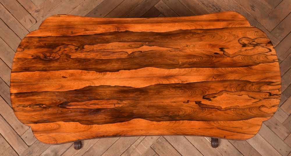 A Victorian rosewood stretcher table featuring a figured top with lobed ends, pierced trestle supports, a barley twist stretcher, and scrolled feet. View VII