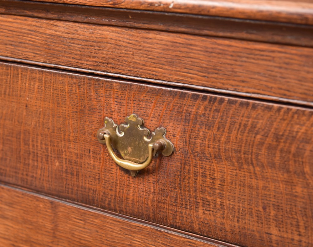A two-tiered nineteenth-century oak court cupboard featuring panelled doors, drop handles on two upper drawers, and turned finials. View IV
