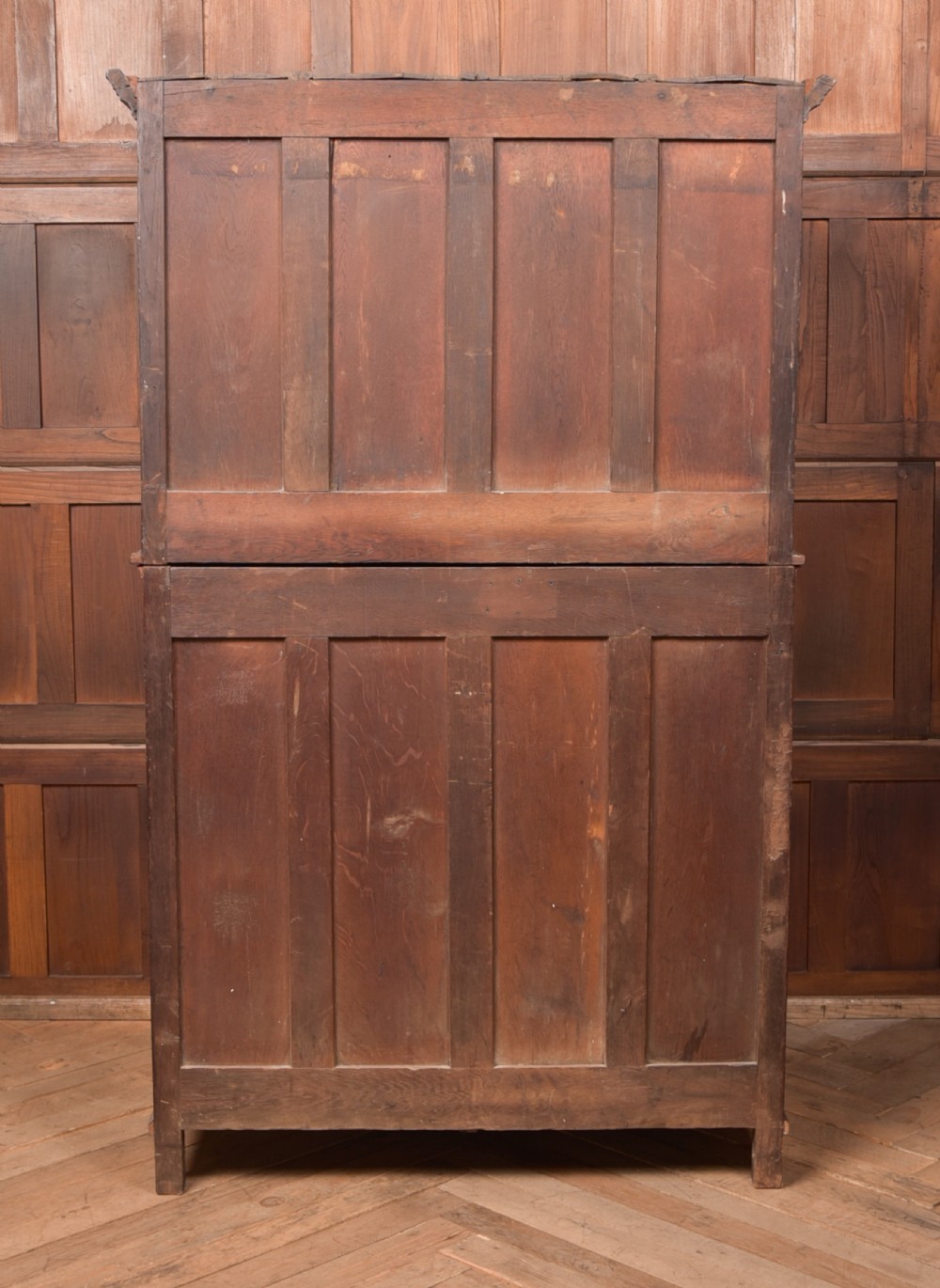 A two-tiered nineteenth-century oak court cupboard featuring panelled doors, drop handles on two upper drawers, and turned finials. View VIII