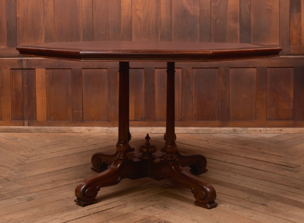 A Victorian octagonal mahogany centre table with a brown leather-inset top, four turned support columns, and a quadruped base with scroll feet. View II