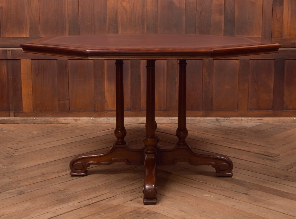 A Victorian octagonal mahogany centre table with a brown leather-inset top, four turned support columns, and a quadruped base with scroll feet. View III