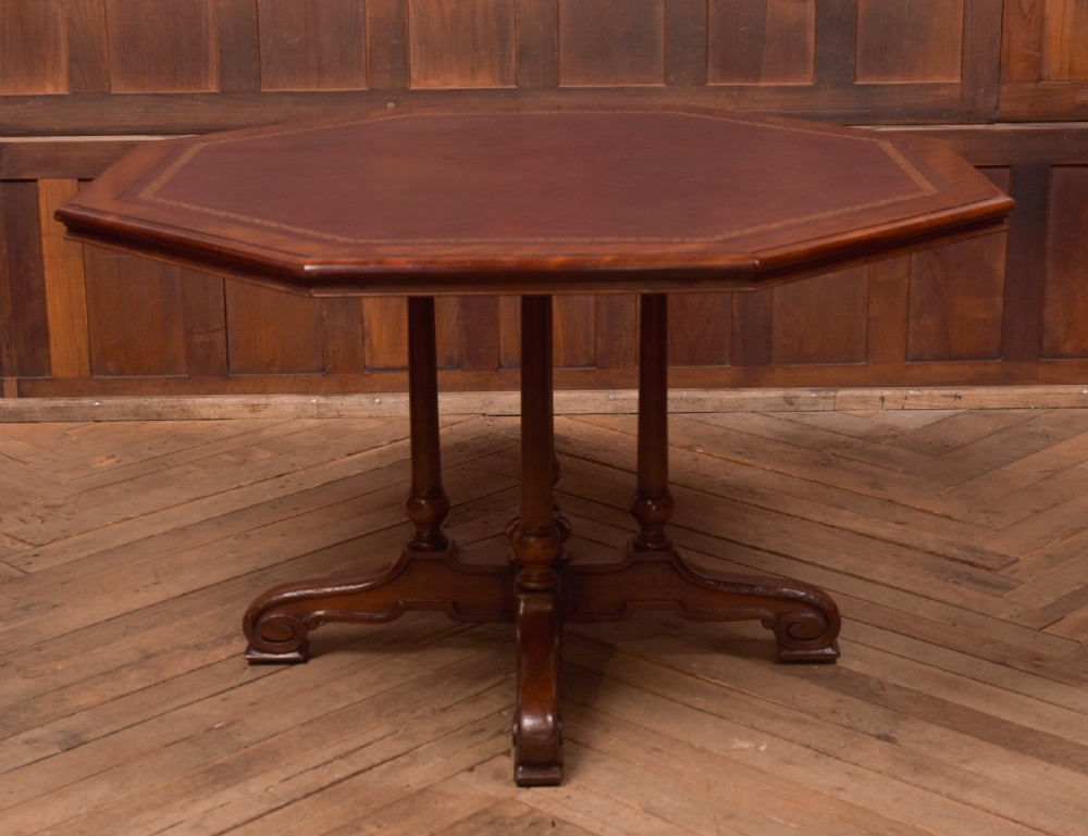 A Victorian octagonal mahogany centre table with a brown leather-inset top, four turned support columns, and a quadruped base with scroll feet. View VIII