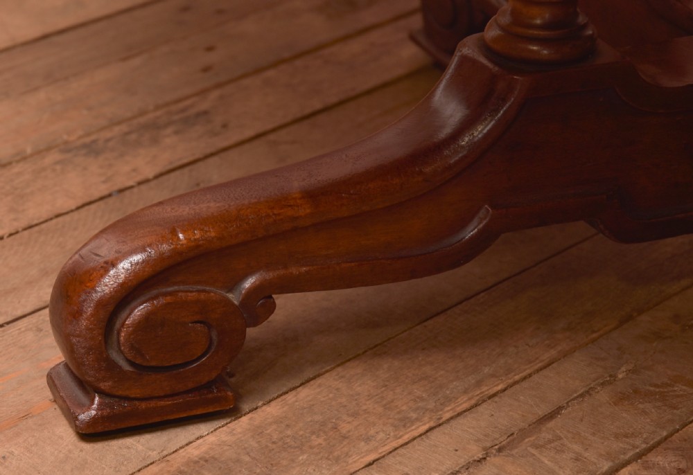 A Victorian octagonal mahogany centre table with a brown leather-inset top, four turned support columns, and a quadruped base with scroll feet. View XII