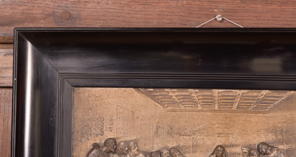 A 19th-century cast metal high-relief plaque depicting The Last Supper mounted inside a deep, black ebonised wooden frame. View III